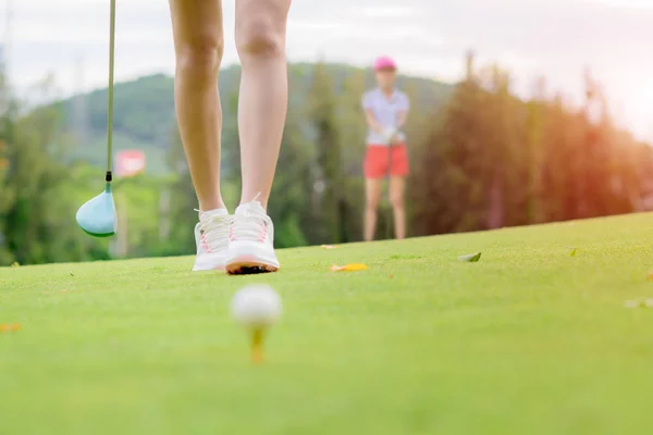 女性のゴルフ選手がフェアウェイにボールを打つためにラインチェックターゲット 相手の競争相手や背景に見てゴルフボールを打つために歩く — ストック写真