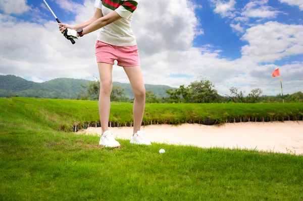 女性のゴルフ選手は 先にトラブルの問題を克服またはソート砂の摩擦のヒットや障害物の上にゴルフボールクロスに集中します スコアラットで勝つために緑の目的地に到達 — ストック写真