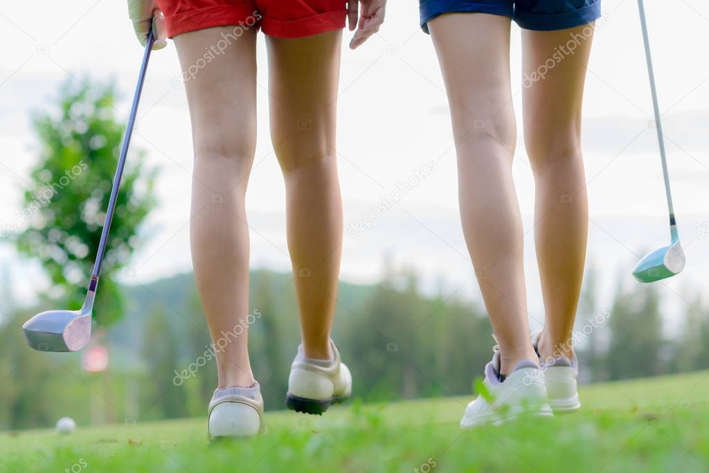 legs of young woman golf players both walking to T-OFF to take next shot hit the ball to the destination fairway
