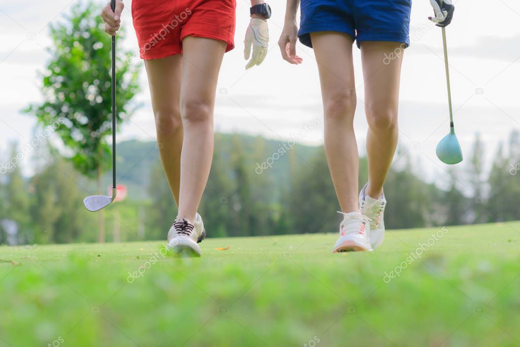 legs of young woman golf players both walking to the fairway after hit the ball from T-OFF, next shot going to takes on the fairway hit to the green
