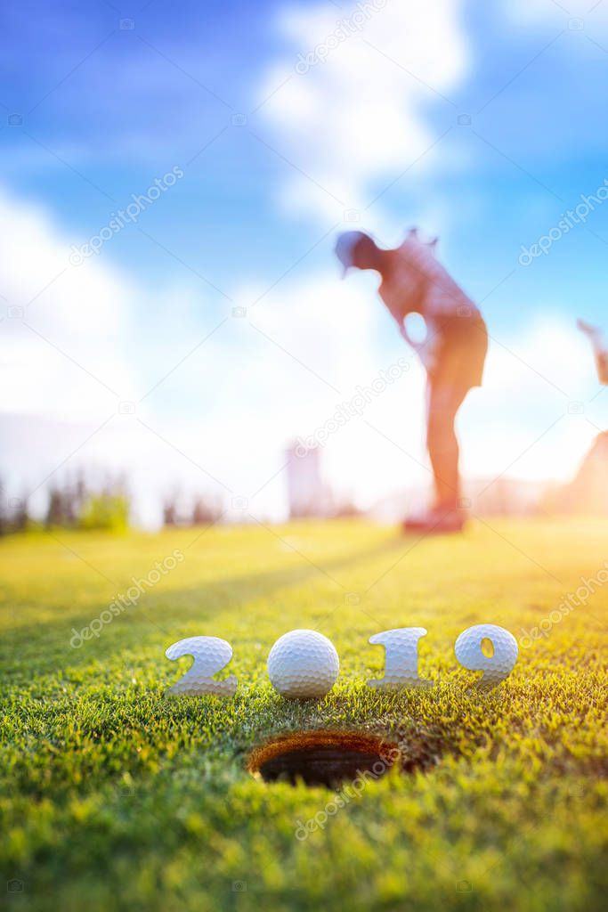 incoming year 2019, prepare by putting of woman golfer on the green,  golfball mostly ready to drop into the hole of new year success, Happy new year and merry Christmas on golf cours
