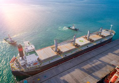 General Toplu Kargo Gemisinin deniz limanı terminalinden ayrılırken havadan görünüşü. Römorkör tekneleriyle güvenli durum yelkeni. Navigasyon komuta pilotu tarafından çekilmeye yardımcı oluyor.