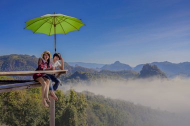 Çift aşıklar, Tayland 'ın kuzey kesimindeki sabah sisi manzarasının keyfini çıkarırlar.