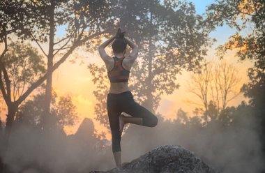 Sıcak kaynak suyunda yoga pratiği yapan genç bir kadın. Sıcak bahar suyunda doğa yogası. Gün doğumunda kaynayan su. 