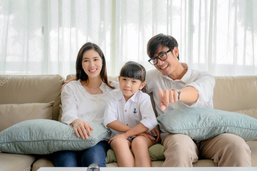 happy family watching TV entertainment together in living room at holiday time weekend, keep watching and teach family member in appropriate content 