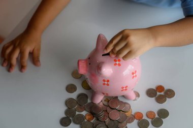 Küçük bir çocuğun elindeki kumbara. Gelecek için para biriktirmeye çalış. Gelecek için bütçe biriktirmeyi öğren.
