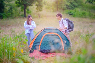 Kadın, başarı çadırındaki adama övgüler ve neşe dolu bir hareketle geceyi burada geçirmeye hazırlanıyor.