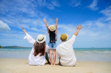 Bir grup mutlu aile tatilde ve uzun tatillerde birlikte deniz kıyısına seyahatin tadını çıkarırlar.