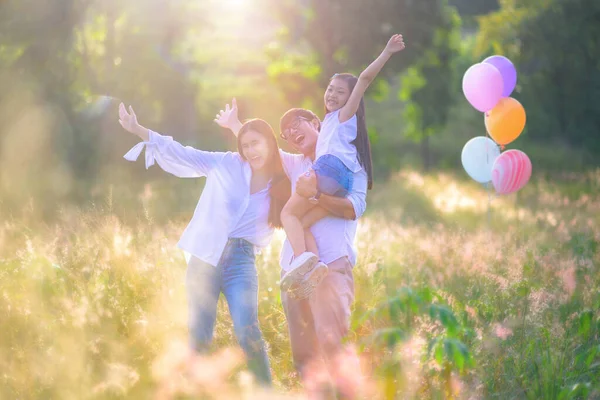 group of warm family enjoy playing together in wildflowers meadow field at light of morning sunrise