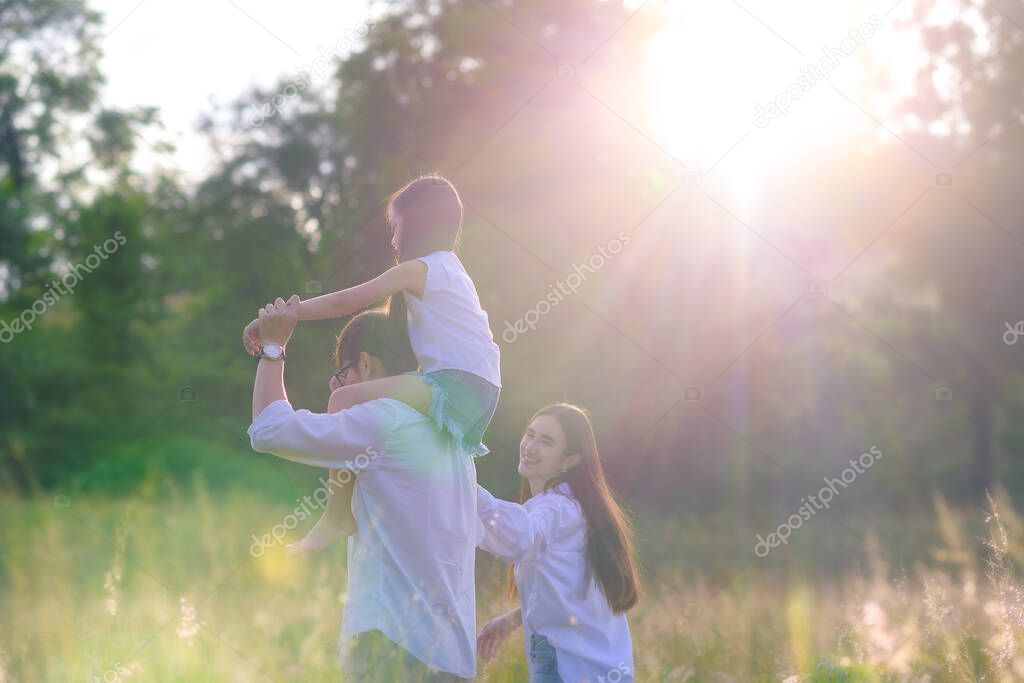group of warm family enjoy playing together in wildflowers meadow field at light of morning sunrise 