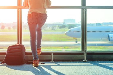 Kadın turist ya da yolcu geç kaldı. Geçit terminalindeki giriş kapısında gecikme var. Uçak terminalden kalkıyor.