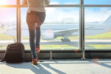 Kadın turist ya da yolcu geç kaldı. Geçit terminalindeki giriş kapısında gecikme var. Uçak terminalden kalkıyor.