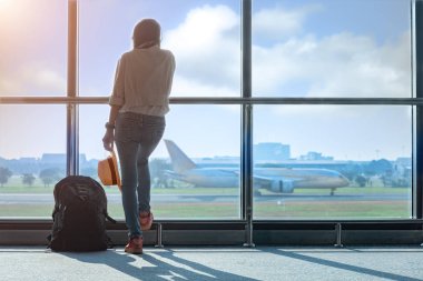 Kadın turist ya da yolcu geç kaldı. Geçit terminalindeki giriş kapısında gecikme var. Uçak terminalden kalkıyor.