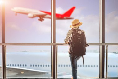 Kadın turist ya da yolcu geç kaldı. Geçit terminalindeki giriş kapısında gecikme var. Uçak terminalden kalkıyor.