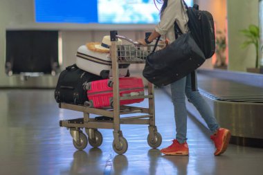 Havaalanı terminalinin transfer kemerinden alındıktan sonra havaalanının varış salonundaki varış noktasında bir kadın yolcu tarafından itilmek ya da çekilmek suretiyle havaalanındaki valiz ve bavullar taşınır.