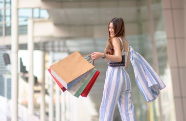 Kadınlar alışveriş merkezlerinde neşeli bir şekilde alışveriş yapmayı severler. Mutlu bir şekilde ellerini havaya kaldırırlar.