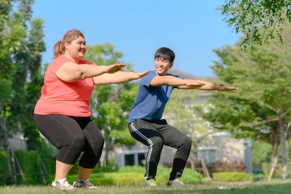 fat plump woman in action of exercise to reduce body weight under instruction of coach or trainer