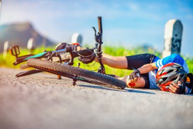fingers hand of young woman support on head, laying down on the floor street, in hurt and injured of leg after accident clashed, with wound and bleeding of blood flow on the surface of street roa
