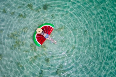 top aerial view of young woman enjoy swimming on floating inflatable tube in sea and cleared water, happy in summertime and vacation or long weekend swimming at sea 