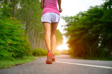 legs of healthy woman jogging alone at daily morning in public park, daily exercise workout running of woman