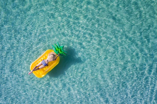 op aerial view of young woman enjoy swimming on floating inflatable tube in sea with cleared water, happy in summertime and vacation or long weekend swimming at sea