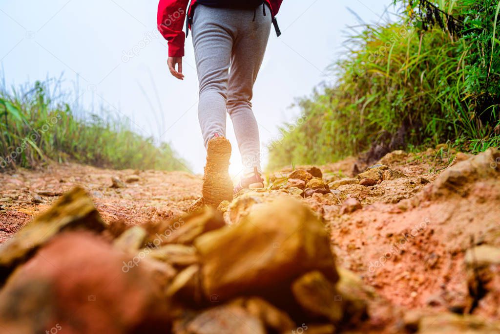 woman traveller trekking step on the way difficult of mud slop suffering to the light and sucess destination ahead