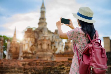 Kadın turist, Tayland 'ın tarihi parkını görmek için yürümekten zevk alıyor. Muhteşem manzarayı keşfetmek heyecan verici.