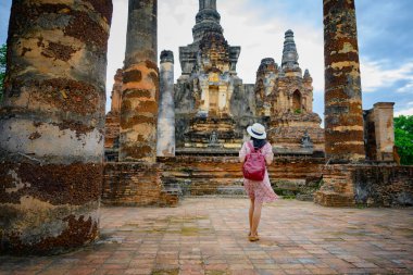 Kadın turist, Tayland 'ın tarihi parkını görmek için yürümekten zevk alıyor. Muhteşem manzarayı keşfetmek heyecan verici.