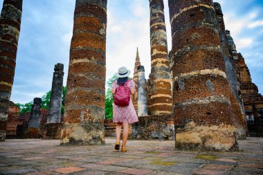 Kadın turist, Tayland 'ın tarihi parkını görmek için yürümekten zevk alıyor. Muhteşem manzarayı keşfetmek heyecan verici.