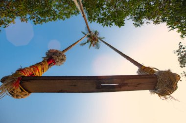 Alçak açılı ahşap salıncak manzarası Hindistan cevizi palmiyesine yapışmış gün batımının ışığında ağaç yaprağının gölgesi altında yaz tatili ve uzun hafta sonu hoş geldin.