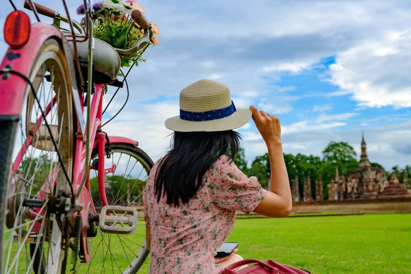 女游客喜欢与老式自行车一起坐着参观泰国的历史公园 兴奋地游览美丽的旅游胜地 — 图库照片