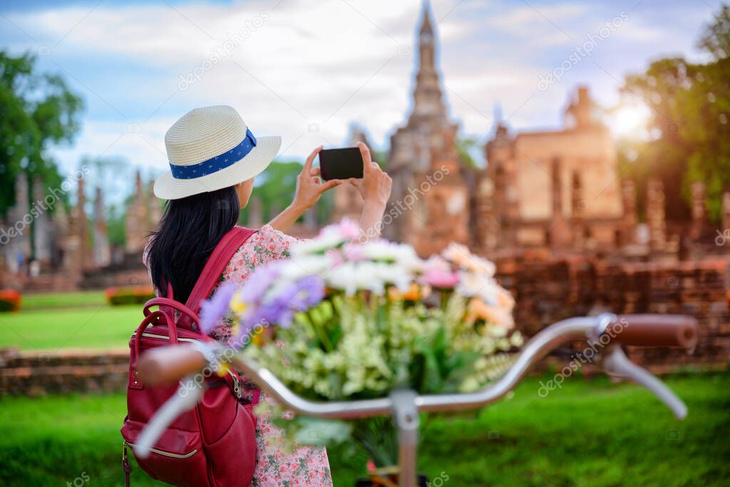 woman tourist enjoy walking to see the historic park of Thailand, exciting taking photo to the wonderful place of sightseeing