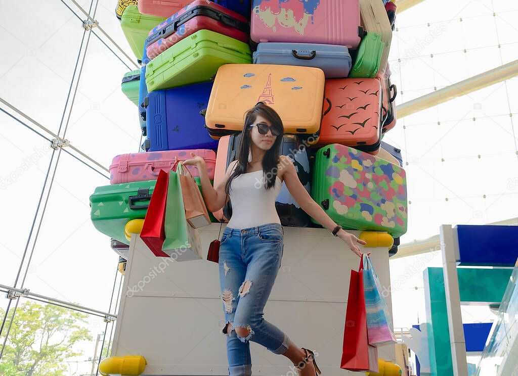 woman enjoy shopping on the mall center, cheerfully at shopping mall, hand up to the air at most happy enjoyment, Luggages and trolley Model in along happiness