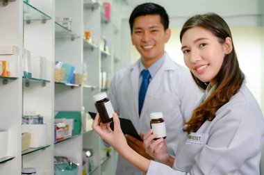 Envanter listesini kontrol etmekle görevli kadın eczacı ve doktor stoklarda kalan veya dengede olan eczane eczanesinde birlikte çalışıyorlar.