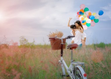 Çayırda dikilen eski bisikletli çayırlarda bekleyen sevgililer, yumuşayan tatlı ve çılgın aşıklar, sevgililer gününde sevgililer günü balonlarla gezintiye çıkan domuzcuklar.