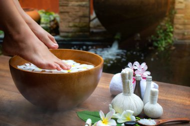Pedikür ameliyatı sırasında bir kadın ve ayaklarının kaplıcada yakın çekimi. Suyun içindeki dişi bacaklar çiçekler, rahatla ve rahat bölge spa terapisi ve tedavisini hisset.