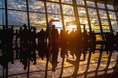 Terminalde bekleyen yolcu silueti. Uçuş kartı olan yolcular uçağa binmek için beklemeye devam ediyor. 