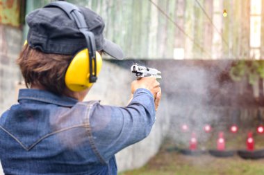 shot gun magazine in hand of old woman is reflect in flicking after shooting bullet away to the target, effective against weight of gun recoil spring works after shooting by stable action