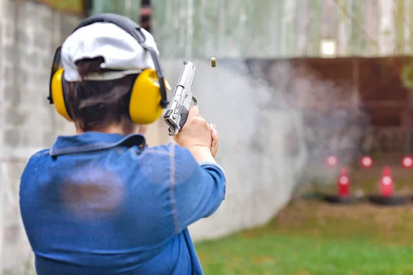 shot gun magazine in hand of old woman is reflect in flicking after shooting bullet away to the target, effective against weight of gun recoil spring works after shooting by Wobble action, for self defense in an emergency case