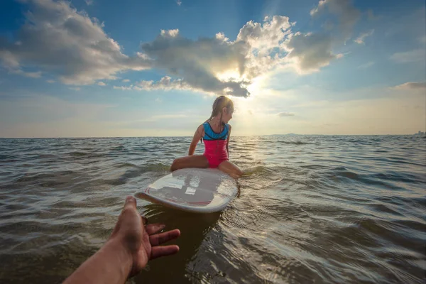 女孩固执而又固执 她拒绝或拒绝让人帮她在海里玩冲浪板 — 图库照片