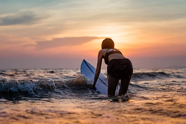 Schlanke Frau Geht Bei Sonnenuntergang Mit Dem Surfbrett Ins Meer — Stockfoto