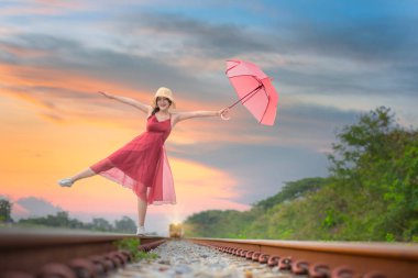 Güzel, eski moda elbiseli bir kadın, tren istasyonunun yakınındaki tren istasyonunda mutlu bir kızla oynaşıyor.