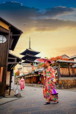 Geleneksel kimono tarzı retro şemsiyeli kadın, sonbaharda bahçe köyünün orta parkında yürüyor, Japonya 'ya geliyor ve spor müsabakalarını ziyaret ediyor.
