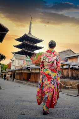 Geleneksel kimono tarzı retro şemsiyeli kadın, sonbaharda bahçe köyünün orta parkında yürüyor, Japonya 'ya geliyor ve spor müsabakalarını ziyaret ediyor.
