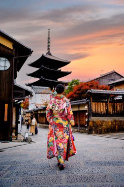 Geleneksel kimono tarzı retro şemsiyeli kadın, sonbaharda bahçe köyünün orta parkında yürüyor, Japonya 'ya geliyor ve spor müsabakalarını ziyaret ediyor.