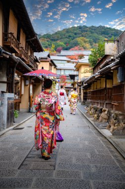 Geleneksel kimono tarzı retro şemsiyeli kadın, sonbaharda bahçe köyünün orta parkında yürüyor, Japonya 'ya geliyor ve spor müsabakalarını ziyaret ediyor.