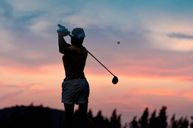 Kadın golfçülerin silueti arka arkaya vurduktan sonra hareket halindeki bir golf topunu sahanlıkta hedefe, hayatın hedefine en iyi şekilde konsantre olmak.