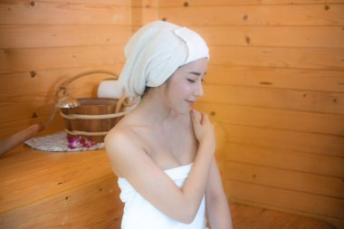 Güzellik merkezi ve rahatlama konsepti. Beyaz kadın sauna odasında dinleniyor..