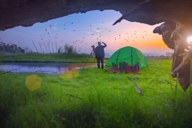 Gezgin gezgin fotoğrafçı, sabahları gölün doğasının tadını çıkar. Tatilde ve kırsalda uzun bir haftasonu seyahatinde.