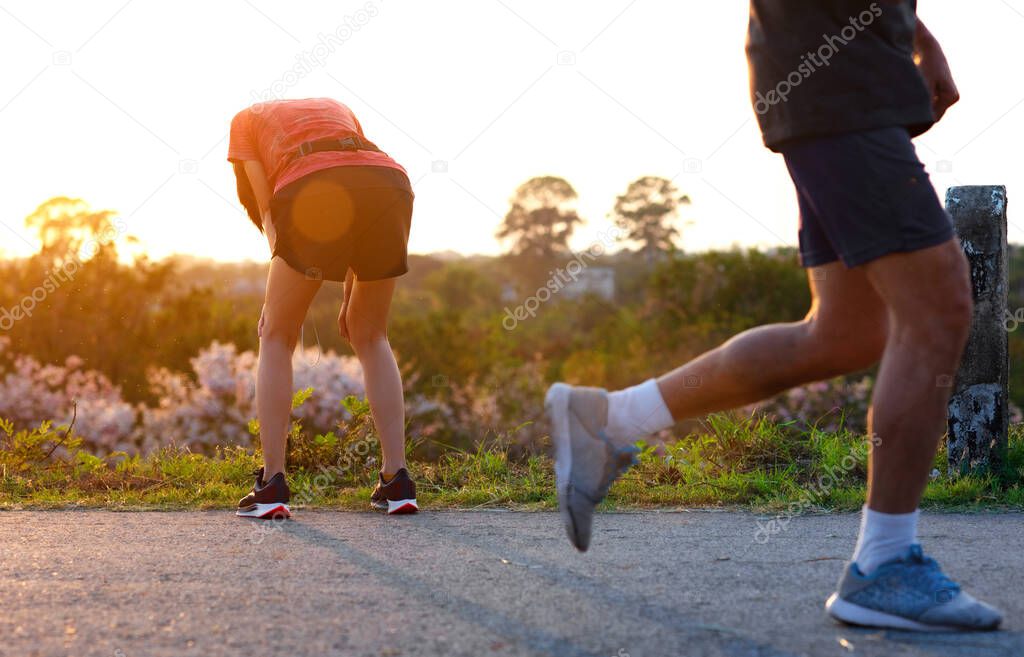 woman tired on running jogging exercise by hand resting on the knees, workout running of woman unfit and tired often